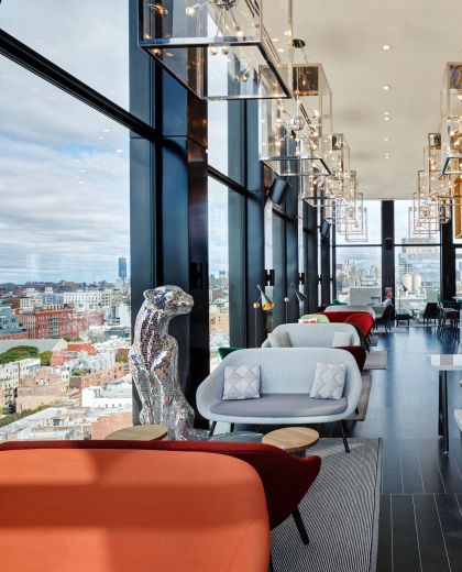 Mirrorball leopard and modern grey furniture at cloudM New York Bowery rooftop bar with view of city below